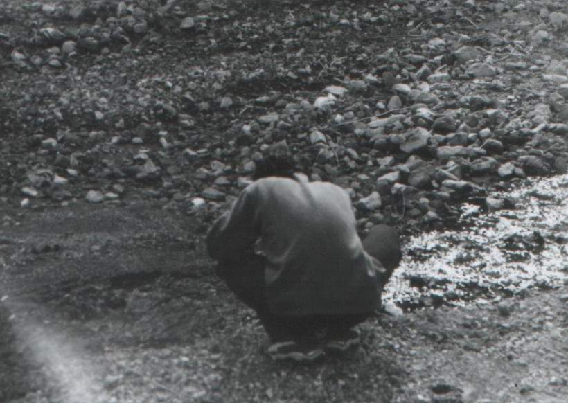 toprakla oynayan adam